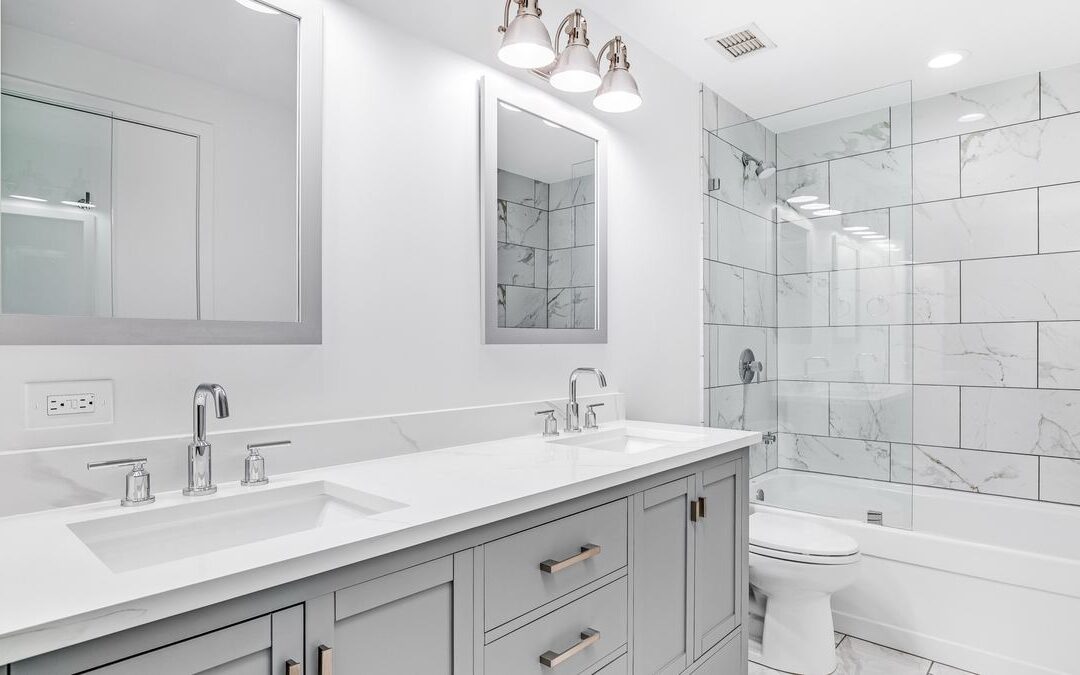 White bathroom with double sinks and a tiled tub surround, a remodel that may need Sacramento bathroom permits
