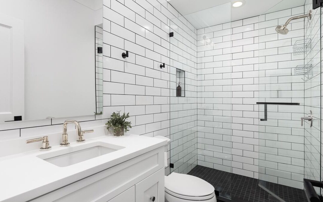 Walk in shower with white subway tile and a glass door, where shower waterproofing basics matter behind the tile